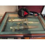 A framed display of bygone brass taps,