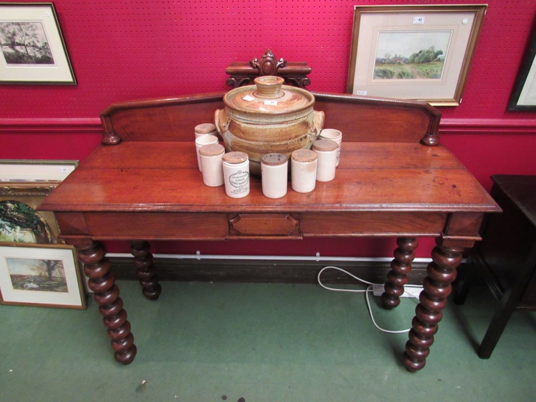 A late Victorian oak serving table the raised back over two frieze drawers on bobbin turned legs,