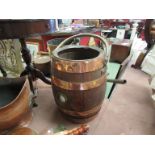 A coopered oak barrel with swing handle,