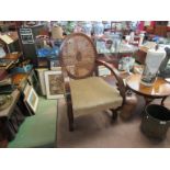 An Art Deco cane back open armchair on shaped foot,