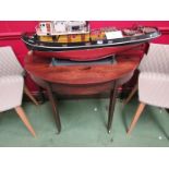 A Georgian mahogany demi-lune table on castors,