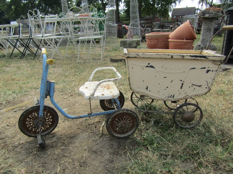 A child's tricycle and a vintage doll's pram (missing one wheel)