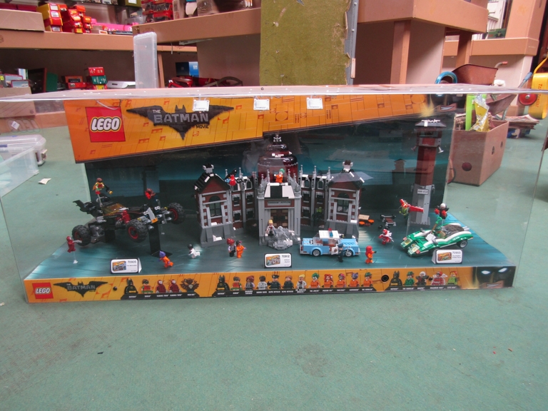 A Lego Batman shop display containing various models including Arkham Asylum