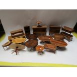 A collection of handmade wooden dolls house furniture including pedestal tables, oak court cupboard,