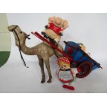 A model camel and wooden cart together with three soft toys
