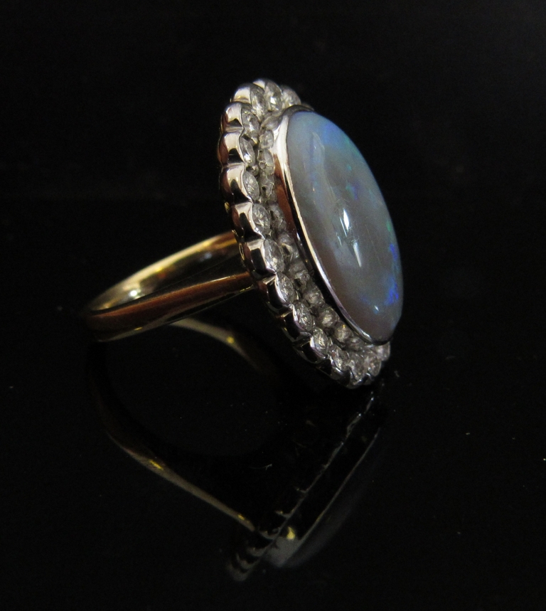 An opal and diamond ring the large oval opal 20mm x 13mm framed by diamonds, stamped 18ct. - Image 2 of 2