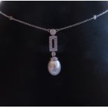 An 18ct white gold chain studded with diamonds hung with a diamond and pearl drop, chain 42cm long,