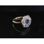A diamond and sapphire daisy ring the central sapphire framed by diamonds, marks rubbed. Size P, 3.