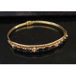 A gold sapphire and diamond daisy bangle stamped 750, 10.