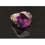 An alexandrite ring set in a floral mount, stamped 10k. Size P, 4.