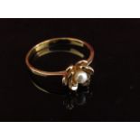A gold ring, unmarked set with a single pearl in floral setting. Size P, 1.