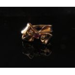 A gold ruby and diamond ribbon bow ring. Size M, 4.