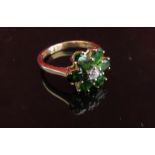 A 9ct gold daisy ring the central white stone framed by green stone petals.