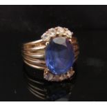 A gold ring with oval sapphire in multi split shoulders, stamped 9ct.