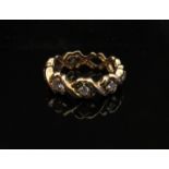 A gold eternity ring with seven diamonds set in open X settings, stamped 14k. Size M, 4.