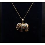 An elephant pendant set with a single sapphire, ruby and emerald with a diamond chip set eye,