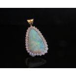 An 18ct gold opal and diamond pendant the opal framed by 30 brilliant cut diamonds,