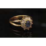 A 14ct gold sapphire and diamond ring, the central oval sapphire framed by diamonds. Size P, 3.