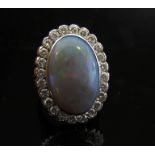 An opal and diamond ring the large oval opal 20mm x 13mm framed by diamonds, stamped 18ct.