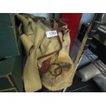 A canvas fishing bag with contents including tins of flies, scales, line,