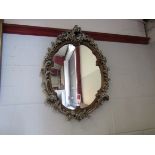 A late 20th Century oval wall mirror in ornate frame