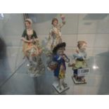A pair of Sitzendorf figures of young couple with lambs together with a pair of figures with