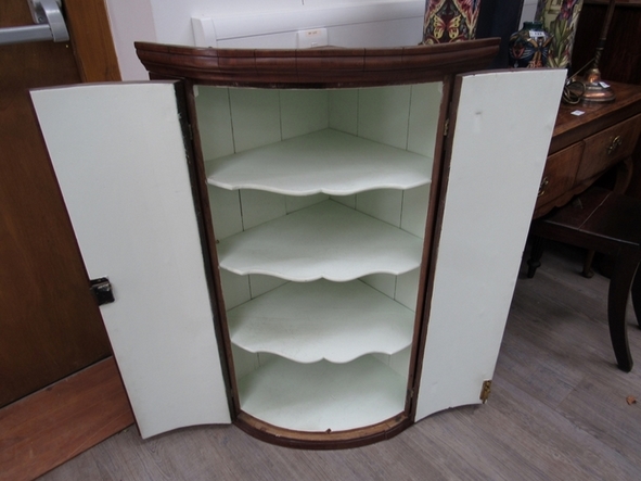 A George III mahogany bow-front wall-hanging corner cupboard with shaped shelves enclosed by a pair - Image 2 of 2