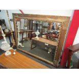 A large gilt framed mirror with foliate scrolled design.
