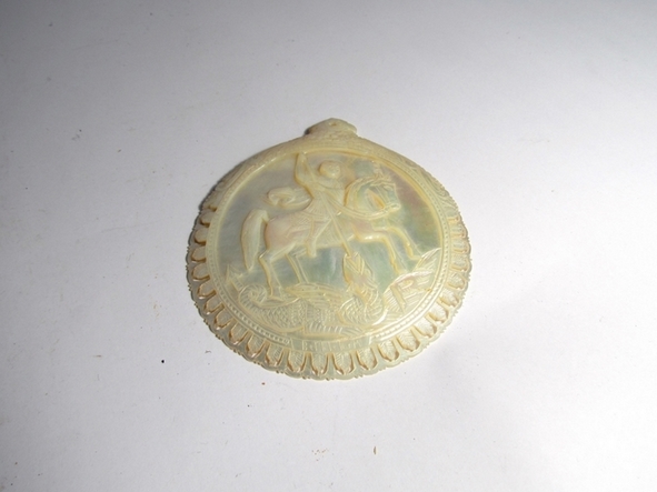 A mother-of-pearl ornately carved token depicting St George and the Dragon, Bethlehem, 11.