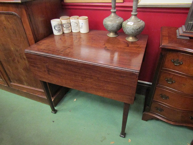 A George III mahogany Pembroke table on chamfered tapering legs and carved feet,