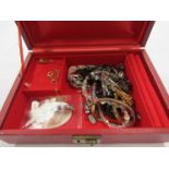 A jewellery box containing mixed costume jewellery including brooches