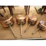A set of four graduating copper saucepans