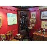 A Georgian mahogany tall corner cupboard with glazed door over cupboard door,