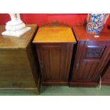 A late Victorian walnut bedside cupboard the carved raised back over a single door on a plinth base,