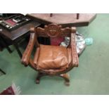 An oak Savonarola "X" frame chair with carved decoration and leather seat,