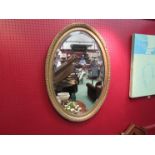 An oval gilt wall hanging mirror,
