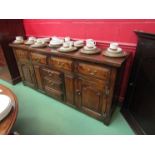 An oak sideboard, four drawers over three drawer two cupboard base, brass swan neck handles,