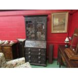 A Victorian oak Green Man bureau bookcase with astral glazed doors and four drawer base,