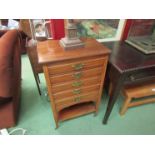 A mahogany five drawer cabinet containing assorted records