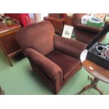 Circa 1920 a pair of club armchairs on bun feet and brass castors,