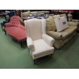 An early 20th Century cream upholstered wingback armchair with foliate design on cabriole legs to