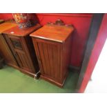 A late Victorian walnut bedside cupboard the carved raised back over a single door on a plinth base,