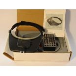 A boxed headworn magnifier with various lenses and LED