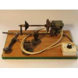 Mounted watchmaker's lathe accessories including two feet, speed reduction pulleys, motor,