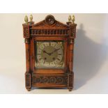 A late Victorian walnut cased mantel clock of architectural design,