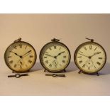 Three early 20th Century French drum form brass cased timepieces with Roman dials and alarms,