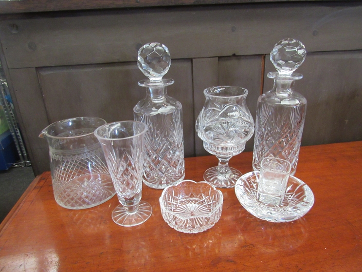 Two crystal decanters together with a selection of crystal items including milk jug and candle