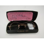 A pair of vintage wire-rimmed spectacles in a case
