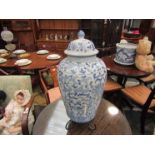 A modern blue and white Oriental lidded vase with metal stand,
