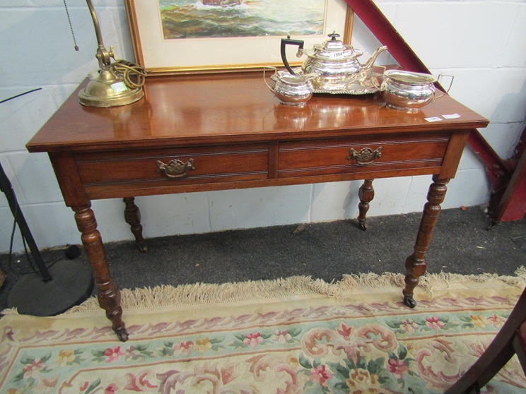 An Edwardian mahogany two-drawer side table on ring-turned legs